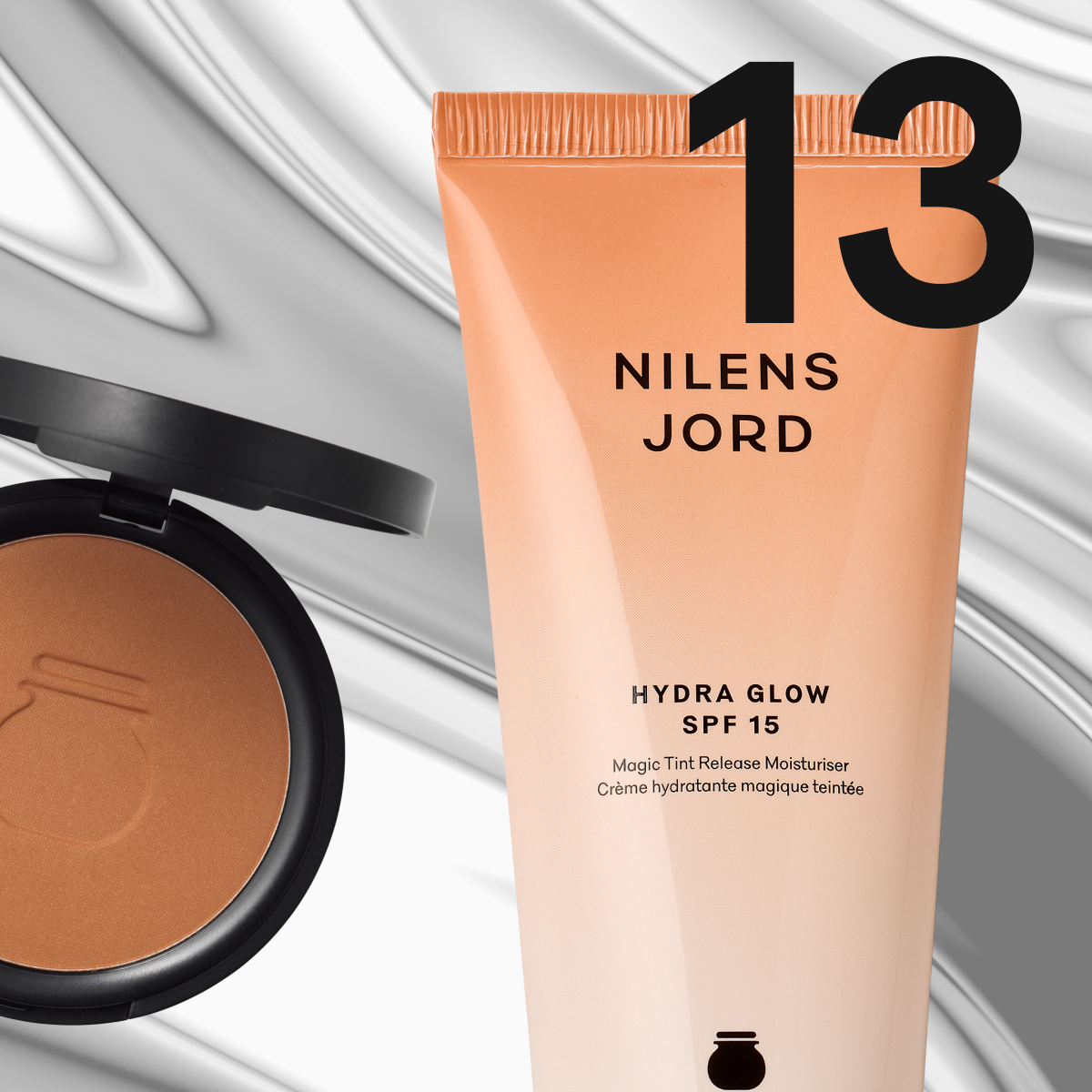 En bronzer och en återfuktande kräm från Nilens Jord i mjuka beige toner mot metallisk bakgrund.