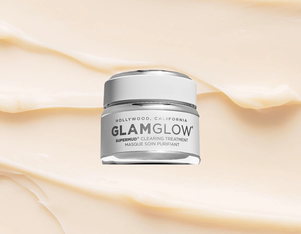 Glamglow’n Supermud beigeä taustaa vasten, jossa on laskoksia.