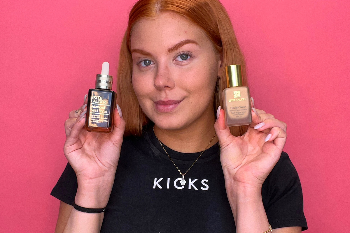 KICKS-medarbeider holder to Estée Lauder-produkter – et serum med pipette i venstre hånd og en foundationflaske i høyre hånd.