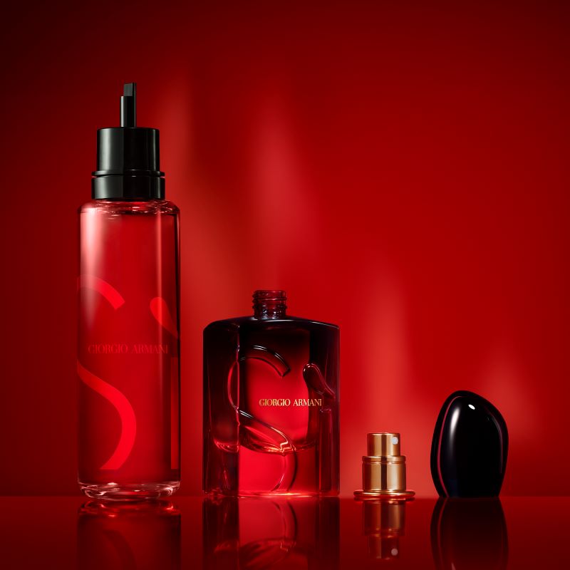 Giorgio Armani-parfymer, begge i røde flasker med svarte og gullfargede detaljer. Den ene flasken er høy og smal, mens den andre er kortere og bredere med avtagbar kork. Bakgrunnen er intens rød.