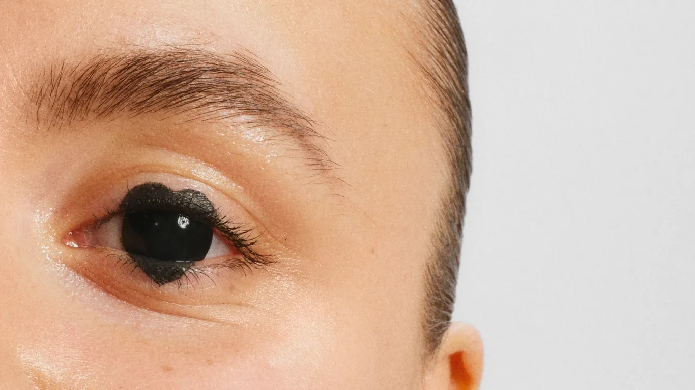 Øye med svart makeupdesign som er formet som et hjerte når det er koblet på svart iris.