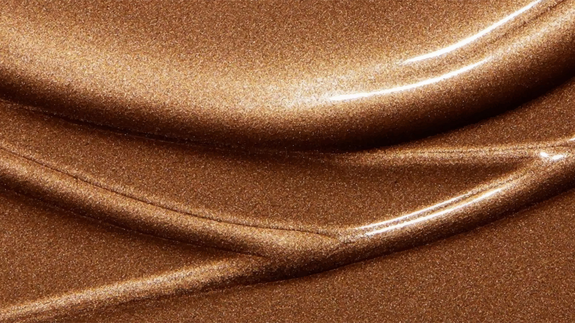 Närbild av en glittrig, metallisk bronzefärgad yta med mjuka, flytande kurvor och glänsande höjdpunkter.