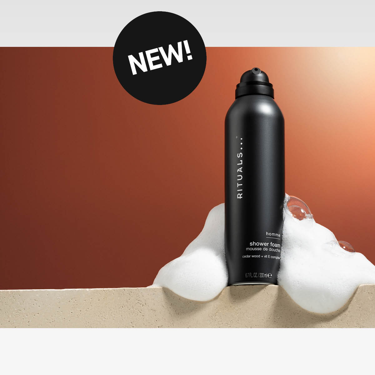 Rituals shower foam för män med synligt skum mot brun bakgrund och sticker med texten "NEW!"