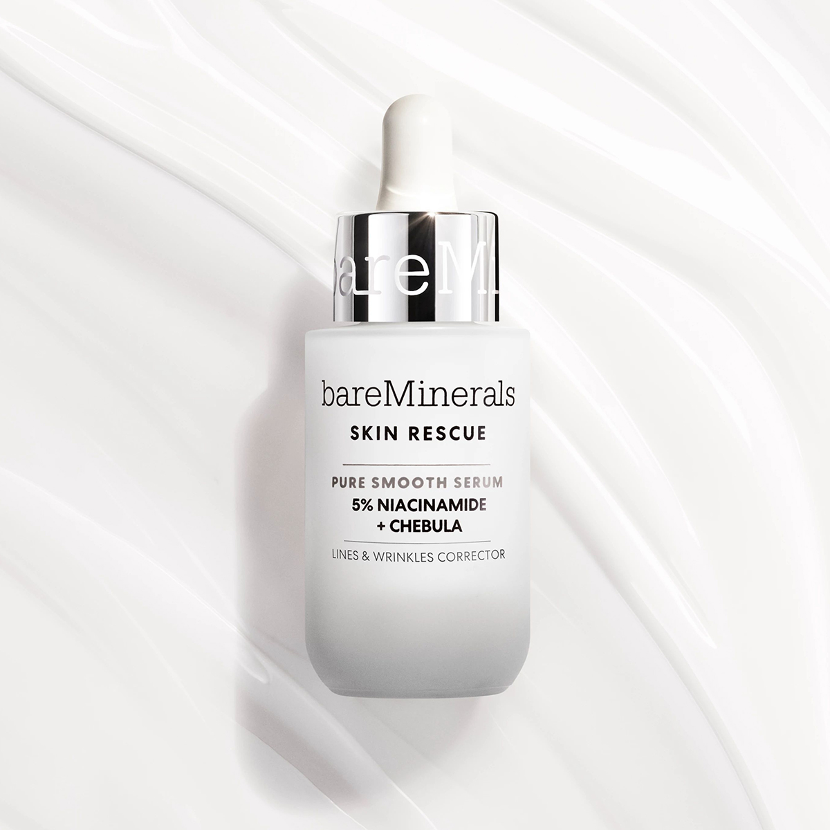 bareMinerals Skin Rescue Pure Smooth -seerumi. Seerumi tulee valkoisessa pullossa, jossa on pipetti ja jonka etupuolella on teksti ”bareMinerals Skin Rescue Pure Smooth Serum 5% Niasiiniamidi + Chebula Lines & Wrinkles Corrector”. Tausta on valkoinen ja siinä on pehmeä, aaltoileva kuvio.