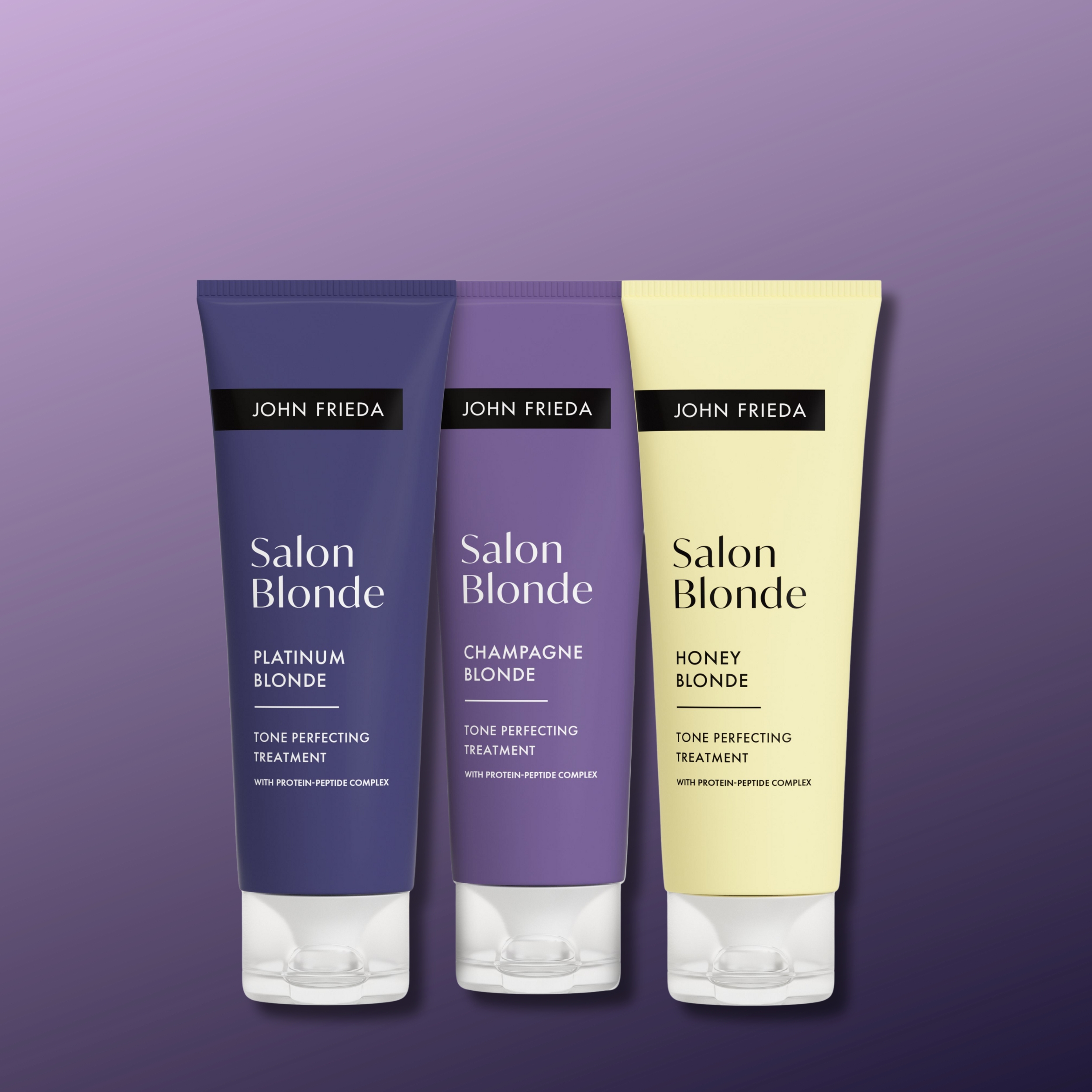 Kolme John Frieda Salon Blonde -tuotetta vaaleanvioletin taustan edessä. Kuvassa on Platinum Blonde, Champagne Blonde ja Honey Blonde sävyjä täydentävä hoito.
