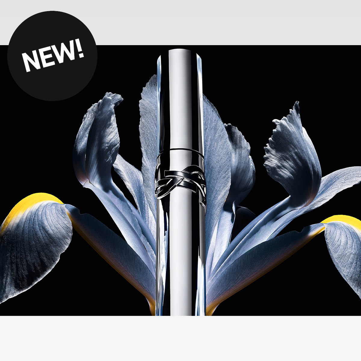 Silverfärgad parfymflaska med blå blommor, med texten NEW!