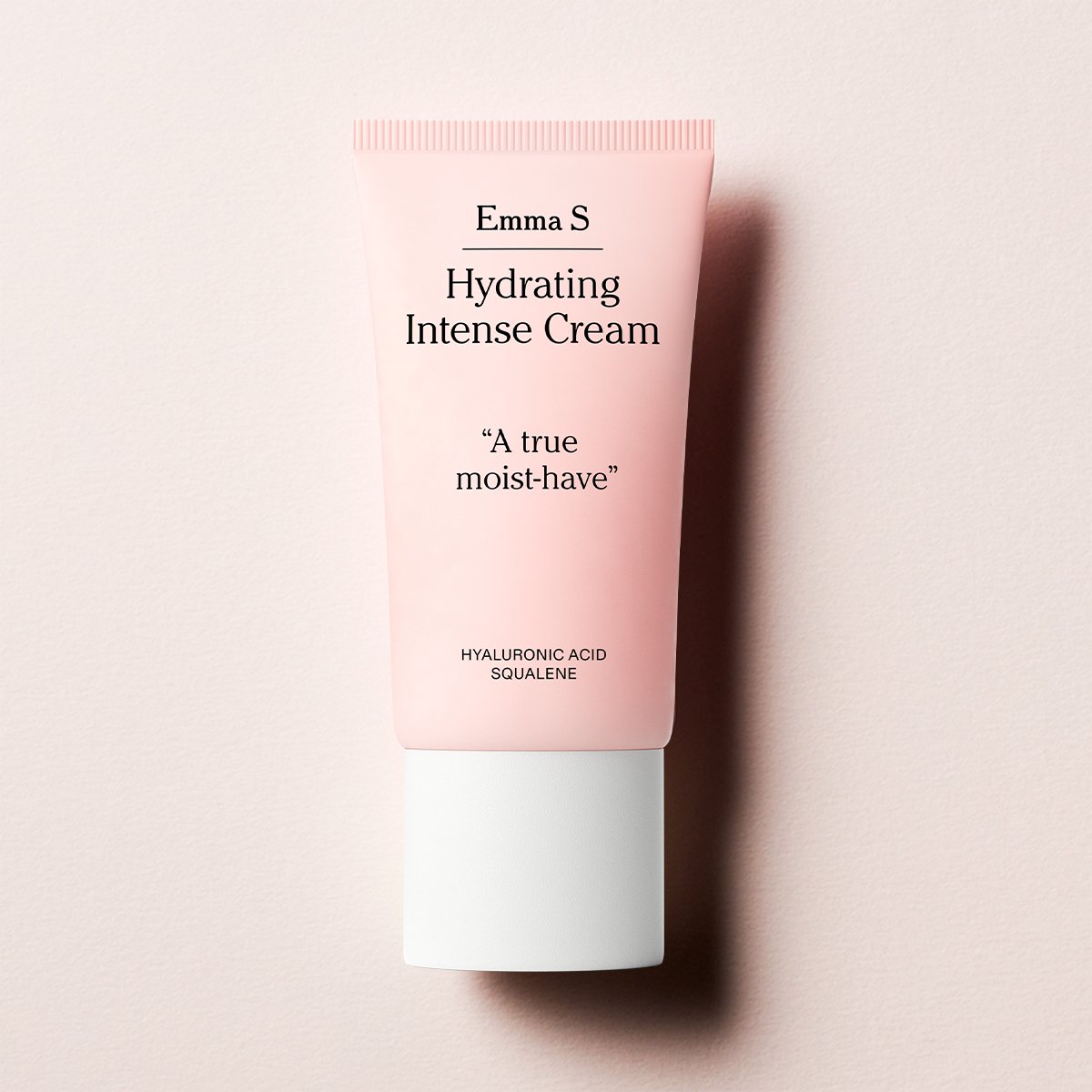 En rosa tub med Emma S. Hydrating intense cream, med texten "A true moist have" på framsidan, placerad mot en ljusrosa bakgrund.