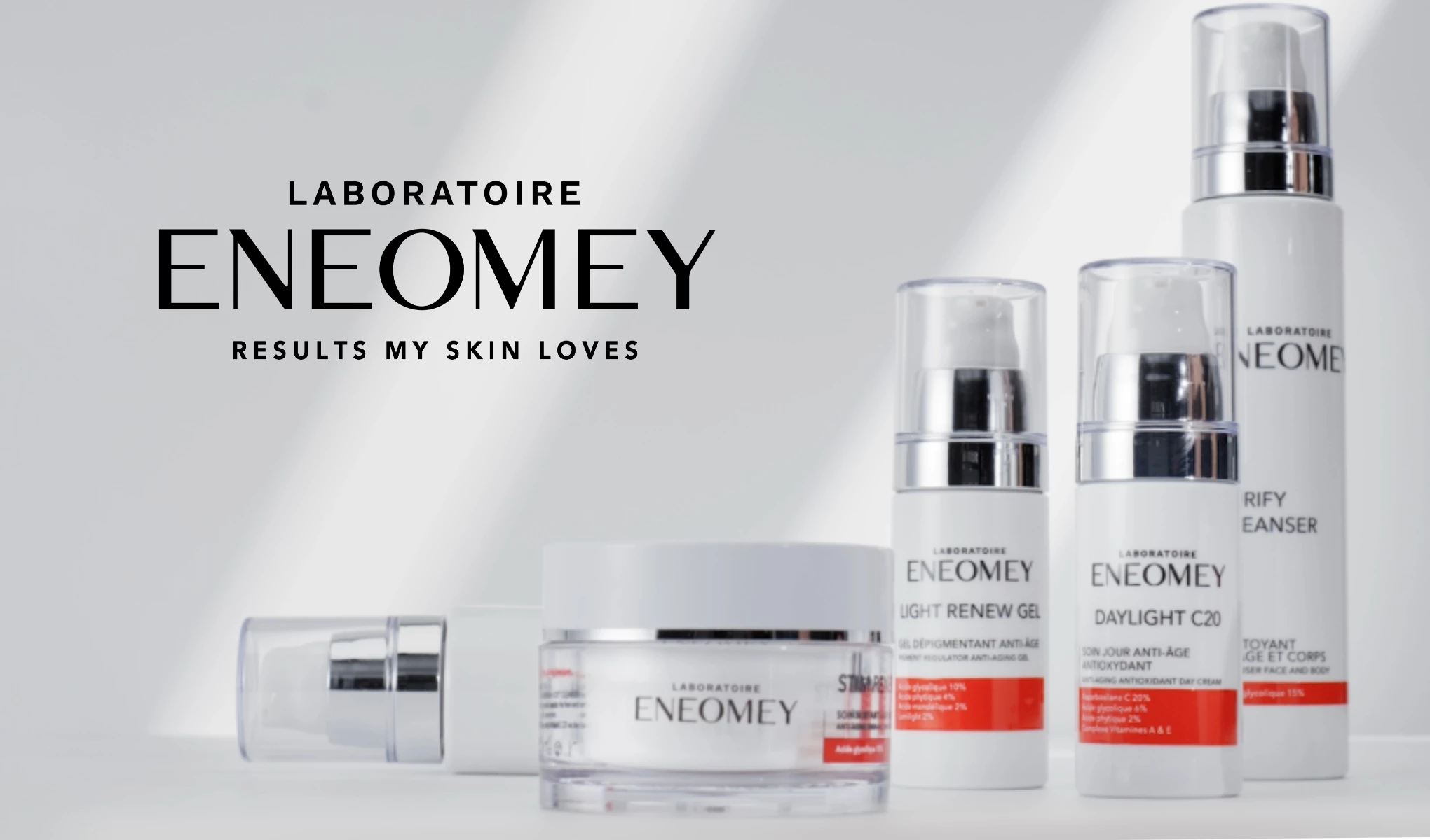 Flera produkter från Eneomey med vit förpackning och röda detaljer. Ovanför produkterna finns Eneomeys logotyp.