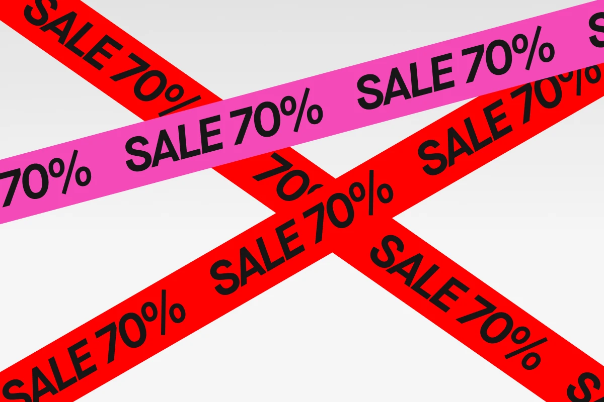 "Vaalealla taustalla ristiin asetetut pinkit ja punaiset nauhat, joissa musta teksti ’SALE 70%’ – graafinen kampanjakuva 70 % alennuksesta."