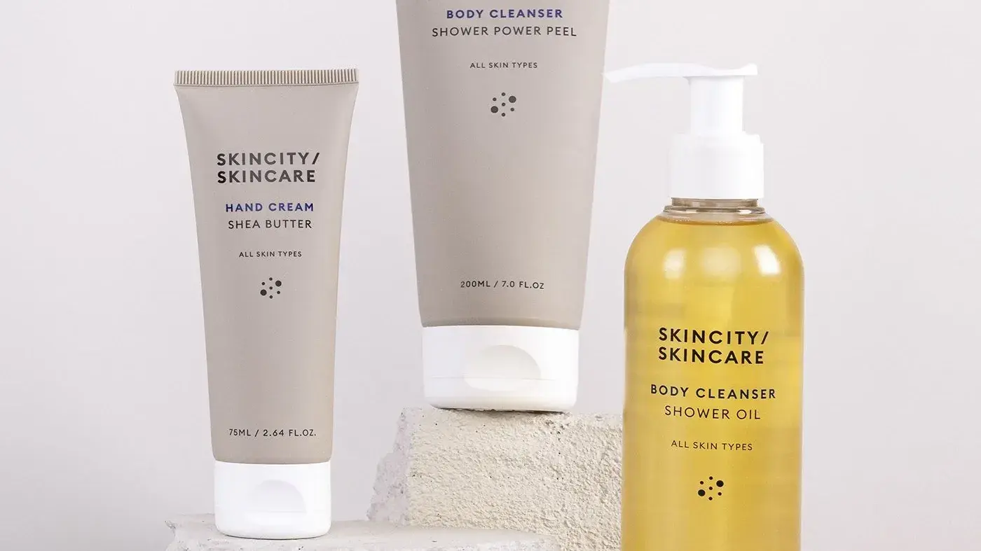 Tre produkter från Skincity Skincare placerade på stenar, mot en grå bakgrund.