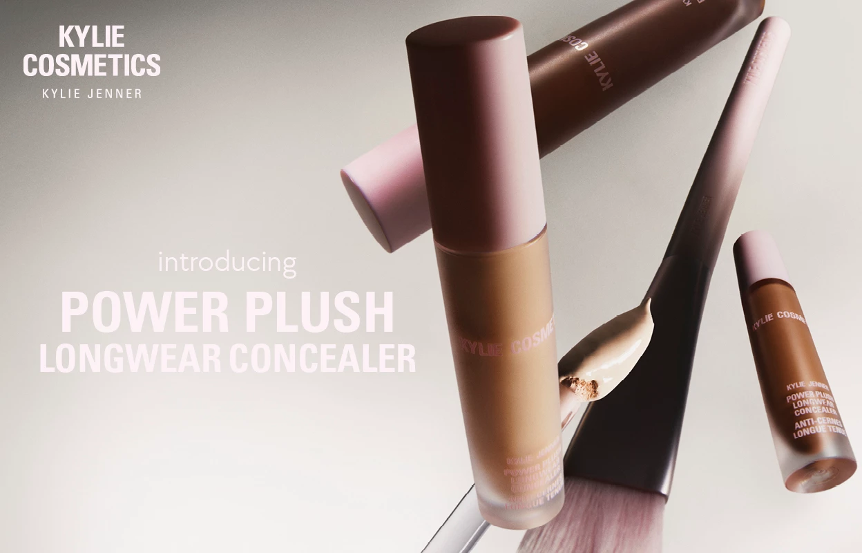 Meikkituotteita, joiden kulmassa on Kylie Cosmeticsin logo, sekä teksti "introducing POWER PLUSH LONGWEAR CONCEALER" vaaleanpunaisella harmaata taustaa vasten.