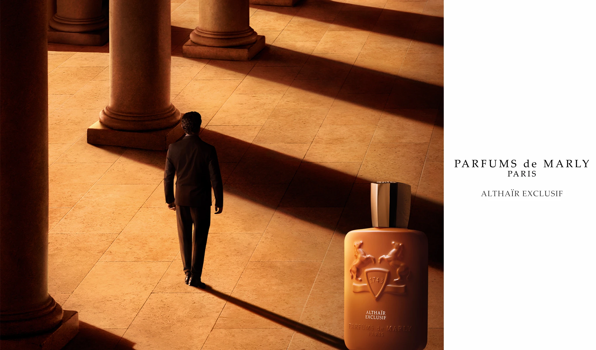 Man går förbi pelare i en skuggad hall. En flaska Parfums de Marly Althaïr Exclusif parfym står i närheten.