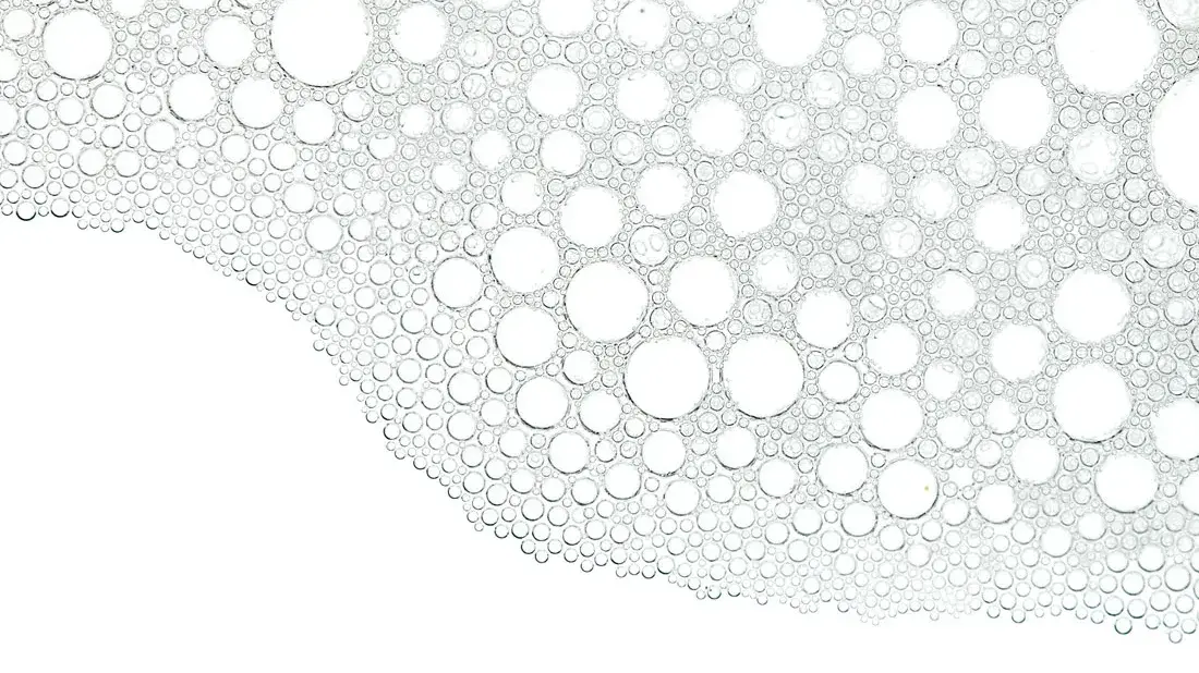 Rakenteettomia kuplia eri kokoisina valkoista taustaa vasten.