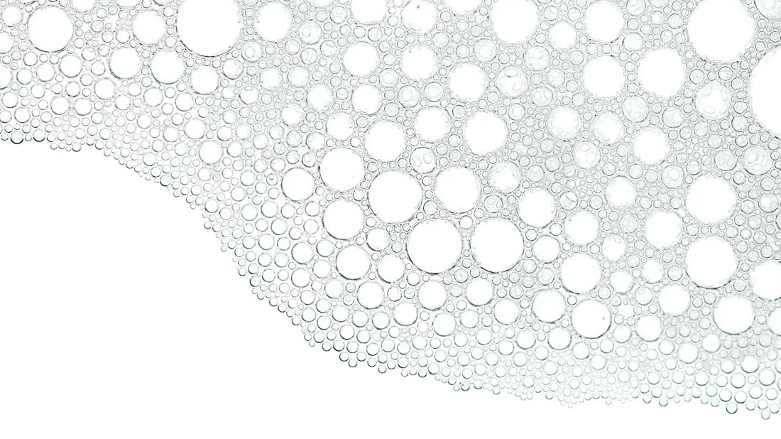 Ostrukturerade bubblor i olika storlekar mot en vit bakgrund.