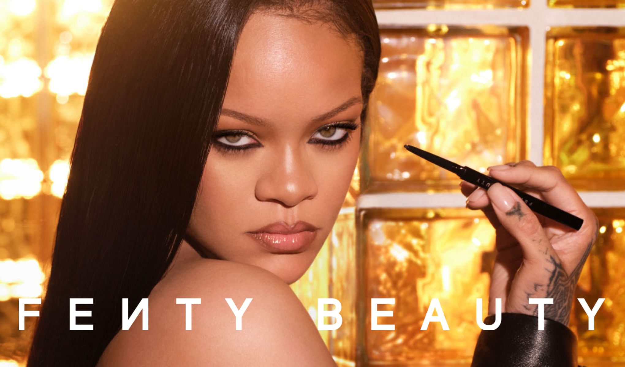 En kvinna håller en Fenty Beauty eyeliner vid ansiktet, med varm gyllene belysning i bakgrunden och texten Fenty Beauty.