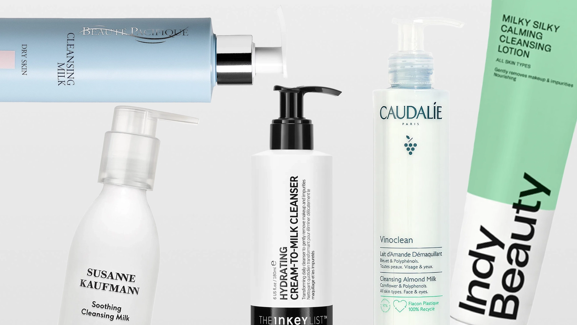 Flera hudvårdsprodukter i form av rengöringsmjölk från bland annat Susanne Kaufmann, The Inkey List, Caudalie och Indy Beauty, med pumpflaskor och tuber mot en ljus bakgrund. Synlig text inkluderar “Soothing Cleansing Milk”, “Oat Cleansing Balm”, “Vinoclean Cleansing Almond Milk” och “Milky Silky Calming Cleansing Lotion”.
