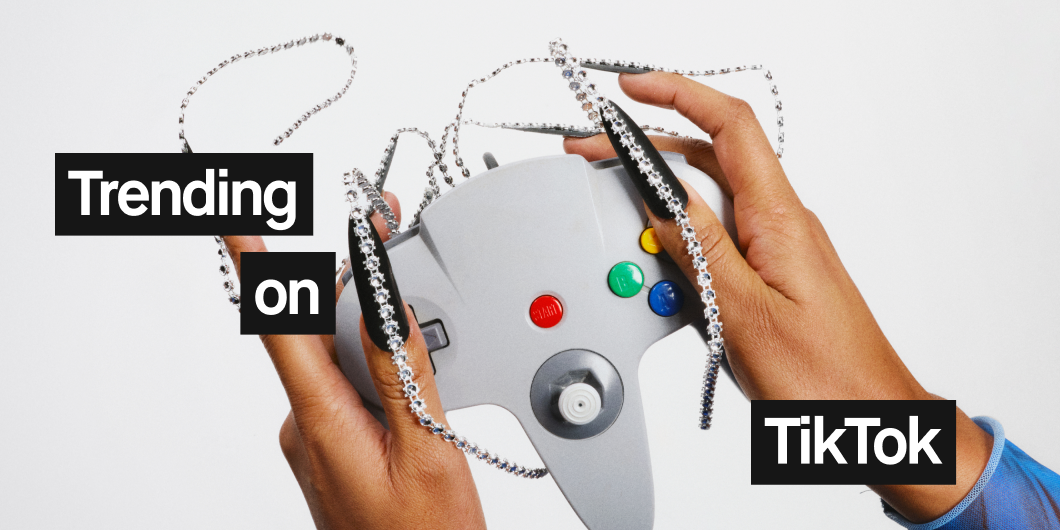 En person håller en spelkontroll med långa, dekorerade naglar. Texten "Trending on TikTok" visas på bilden.