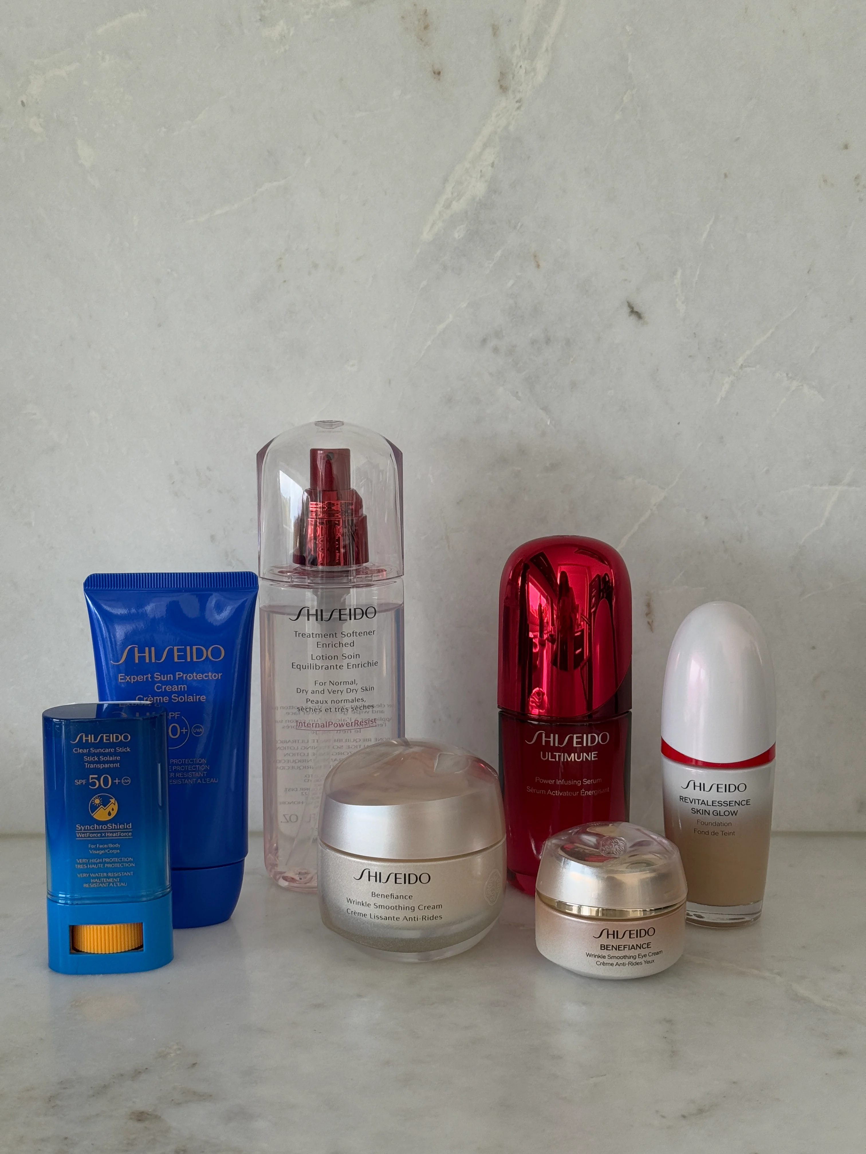 En samling av Shiseido hudvårdsprodukter inklusive serum, ansiktskräm och solskydd, arrangerade på en marmoryta.