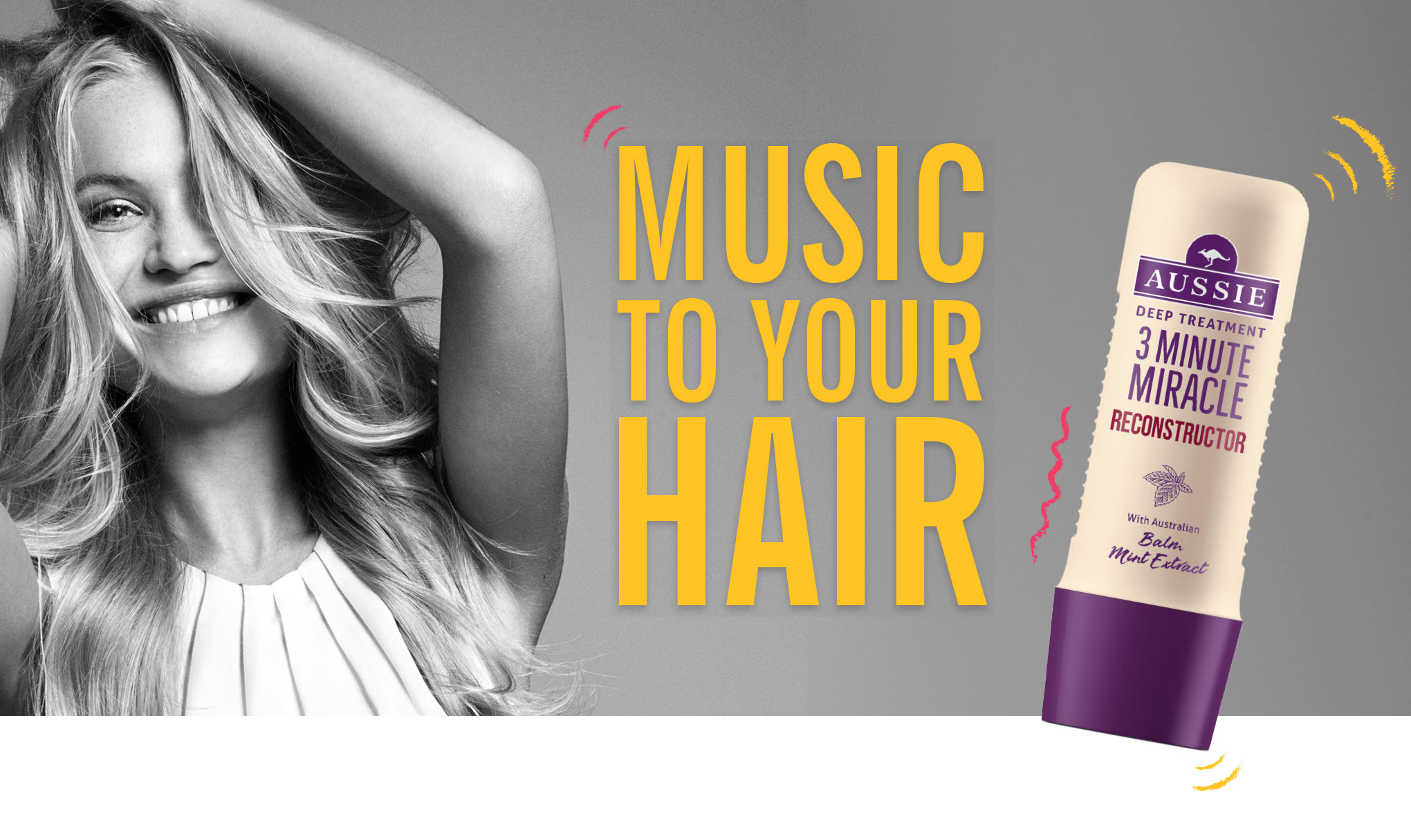 Bilde av hårproduktet «Aussie 3 Minute Miracle Reconstructor». Til venstre er et svart-hvitt bilde av en kvinnelig modell med langt, bølget hår. Teksten «Music to your hair» står skrevet med store gule bokstaver ved siden av produktet.