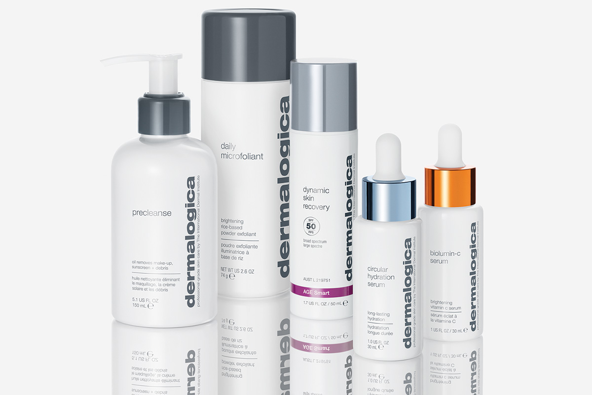 Fem hudvårdsprodukter från märket Dermalogica. Produkterna står på en reflekterande yta som skapar en spegeleffekt. Bakgrunden är ljus och neutral.