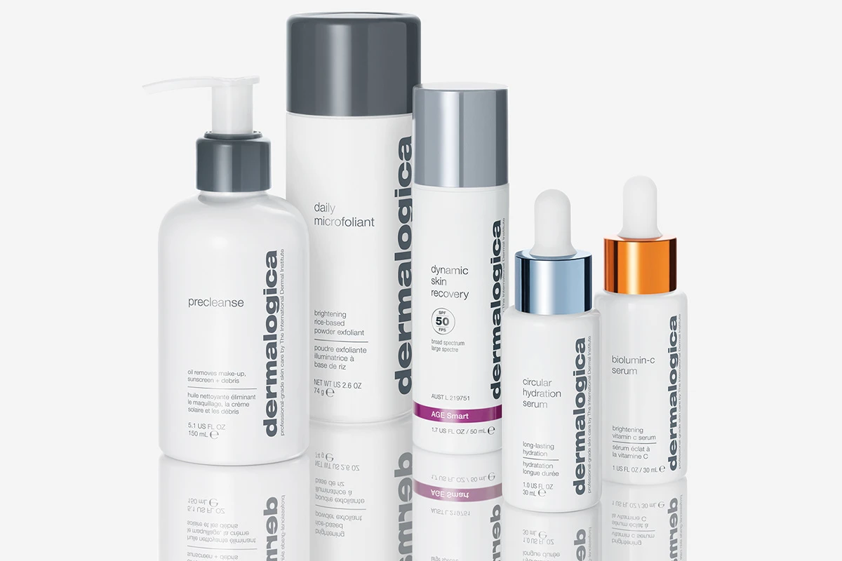 Fem hudvårdsprodukter från märket Dermalogica. Produkterna står på en reflekterande yta som skapar en spegeleffekt. Bakgrunden är ljus och neutral.