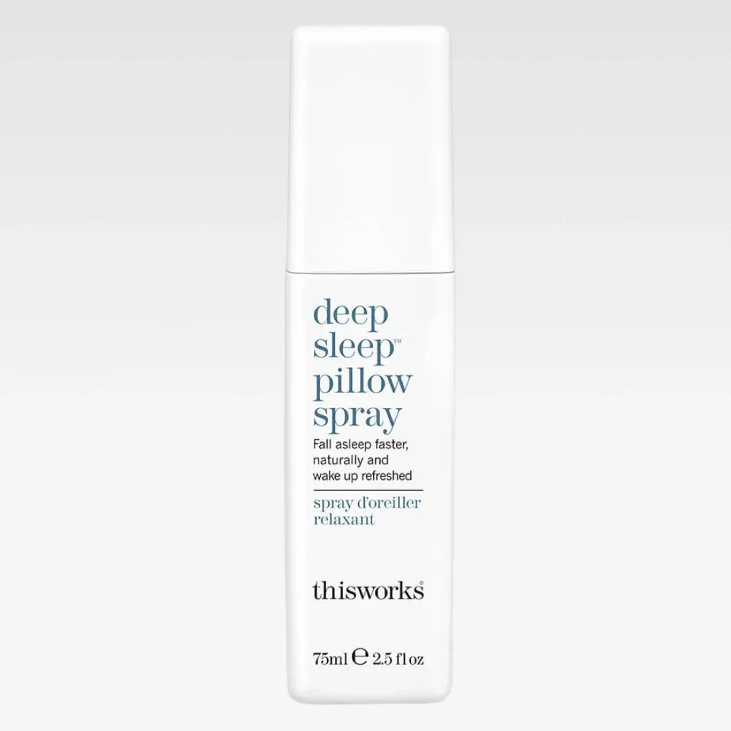 Vit sprayflaska från thisworks deep sleep pillow spray på ljusgrå bakgrund. Texten “Fall asleep faster, naturally and wake up refreshed” och “75ml e 2.5 fl oz” syns på förpackningen.