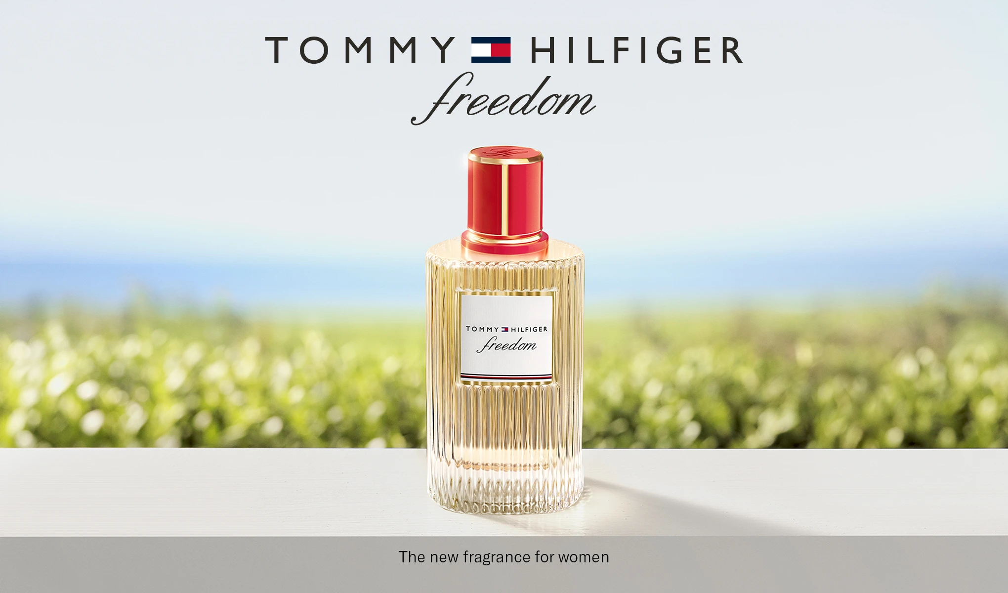 Tommy Hilfiger Freedom-parfymflaska i en ljus miljö. Text: ”Tommy Hilfiger Freedom. The new fragrance for women.”