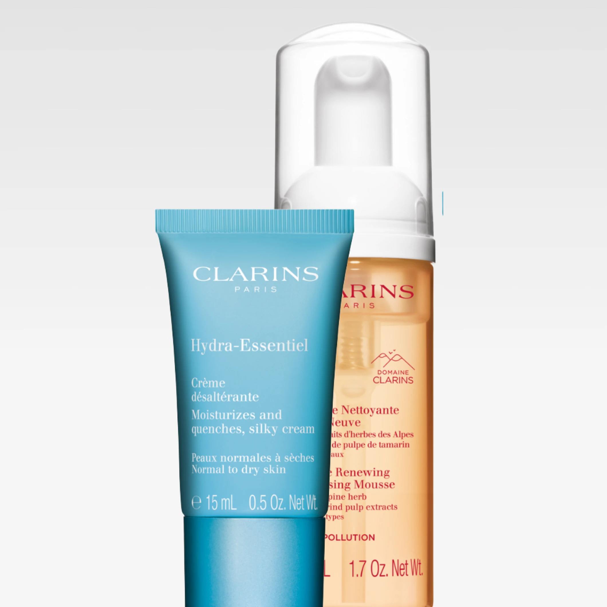 Clarins hudvårdsprodukter mot ljusgrå bakgrund med Hydra-Essentiel ansiktskräm i blå tub och Gentle Renewing Cleansing Mousse i transparent pumpflaska. Synlig text inkluderar “CLARINS PARIS”, “Hydra-Essentiel”, “Moisturizes and quenches, silky cream”, “Normal to dry skin” och “Gentle Renewing Cleansing Mousse”.