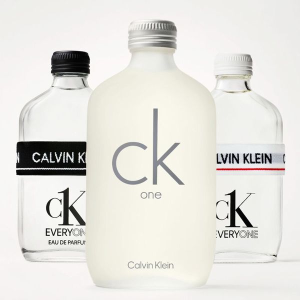 Tre parfymer från Calvin Klein med namnen "ck one" och "ck everyone". Den främre flaskan är frostad vit med grå text, medan de två bakre flaskorna är genomskinliga med svarta och vita korkar samt elastiska band med texten "Calvin Klein". Bakgrunden är vit.