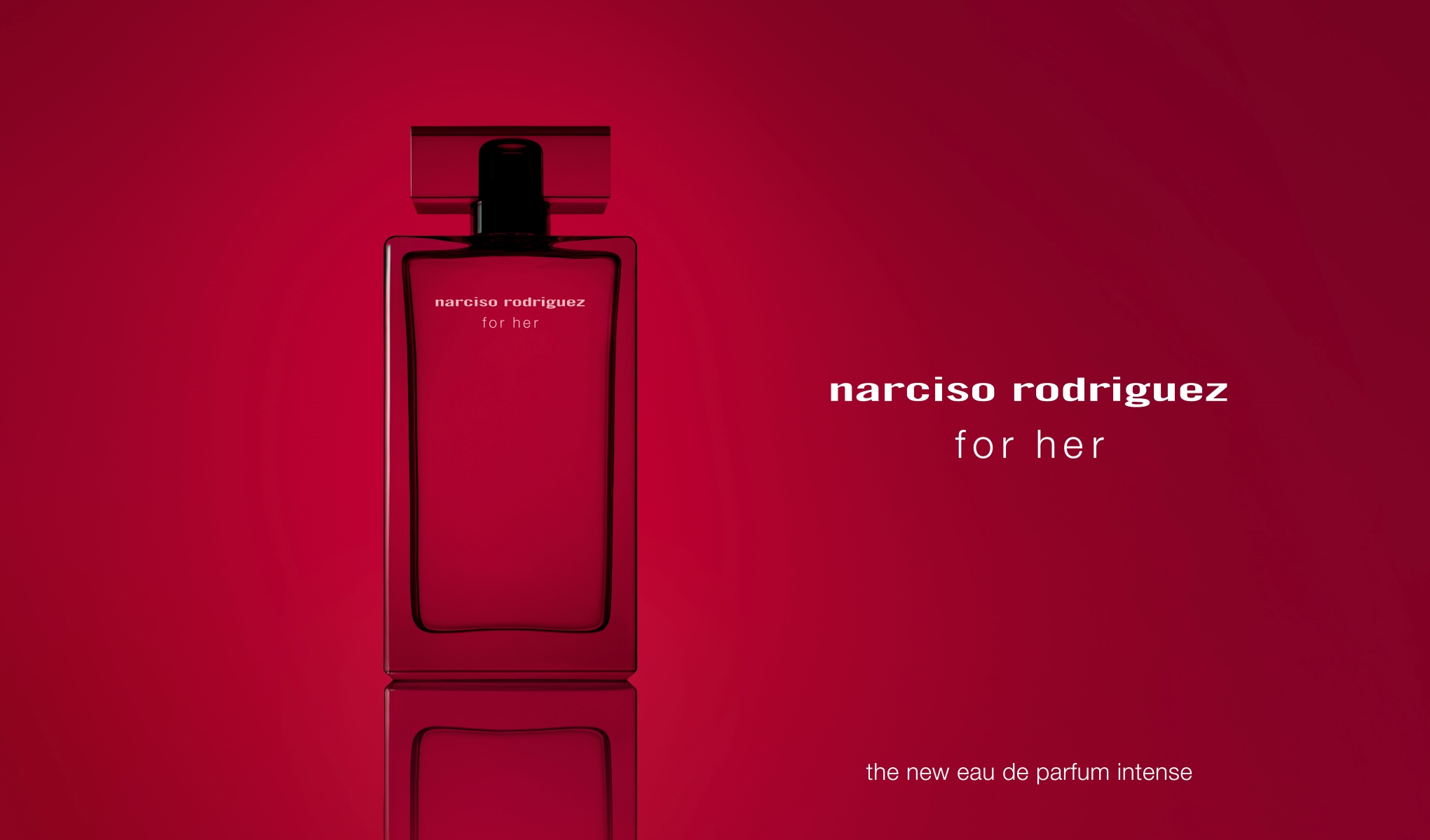 Narciso Rodriguezin hajuvesipullo, jossa teksti ”for her”. Pullo on punainen ja seisoo punaista taustaa vasten. Pullon oikealla puolella on teksti ”narciso rodriguez for her” ja oikealla alhaalla teksti ”the new eau de parfum intense”. Tausta ja pullon väri korostavat hajuveden intensiivistä ja eleganttia luonnetta.