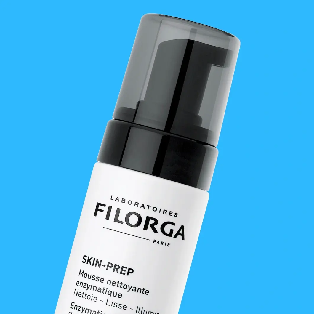 Filorga Skin-Prep entsymaattinen puhdistusvaahto. Valkoinen pullo mustalla pumpulla ja läpinäkyvällä korkilla. Teksti: Puhdistaa, Tasoittaa, Heleyttää.