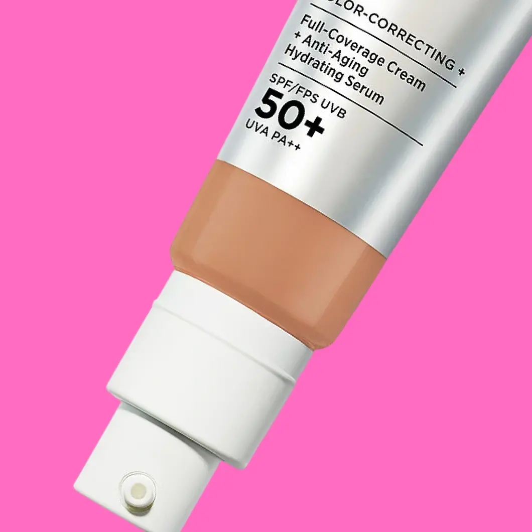 Full-Coverage Cream + Anti-Aging Hydrating Serum SPF/FPS UVB 50+ UVA PA++ -kosmetiikkapullo pinkillä taustalla.