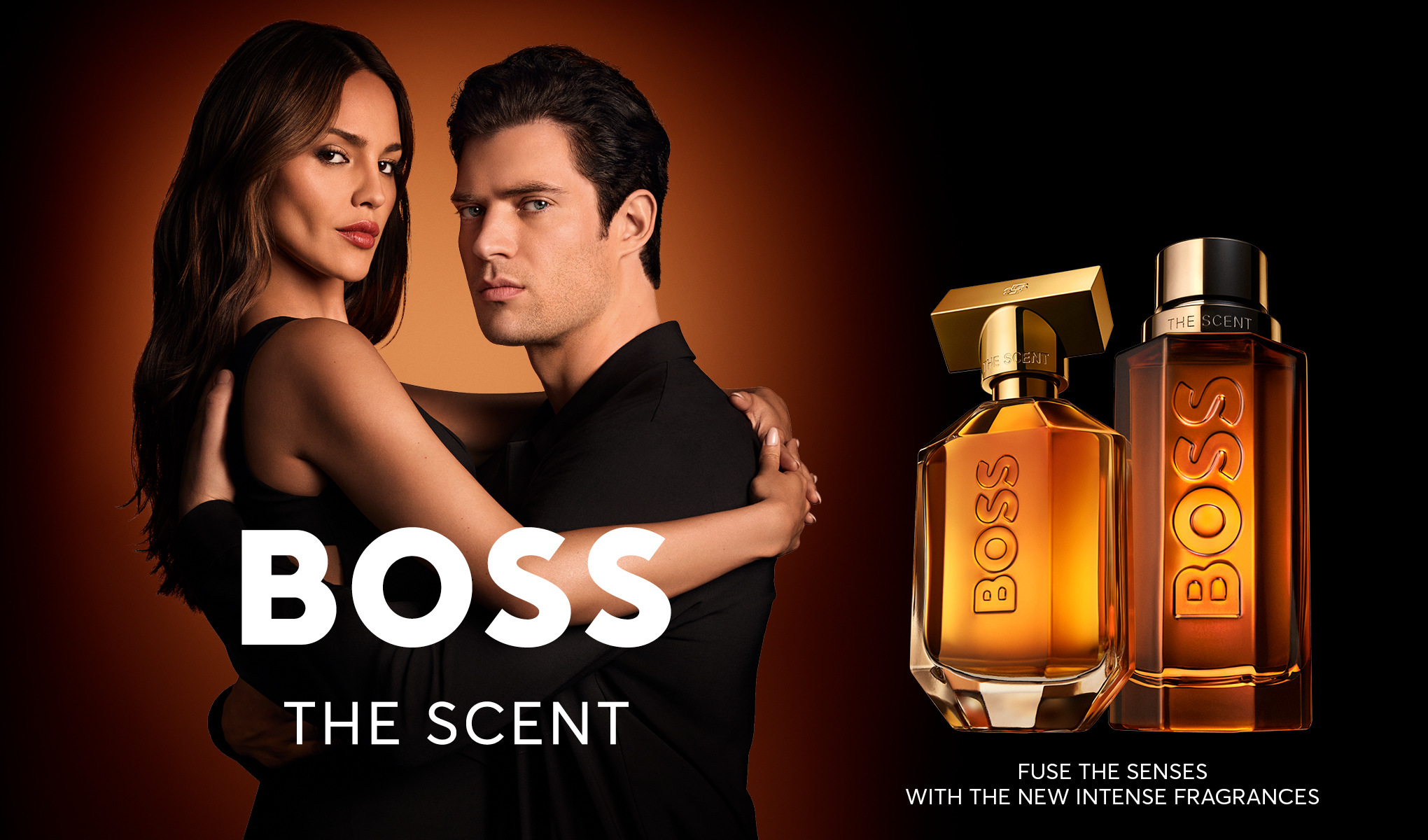 Hugo Boss The Scent -parfyymimainos, jossa mies ja nainen sekä kaksi meripihkanväristä pulloa.