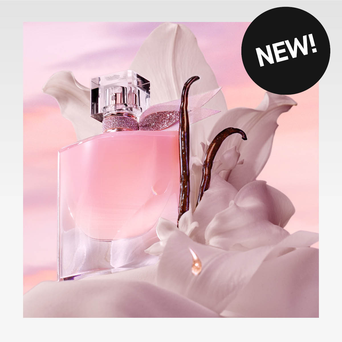 Lancôme-hajuvesi "Vanilla Nude" vaniljatankojen kanssa vaaleanpunaista taustaa vasten. Musta tarra tekstillä "NEW!".
