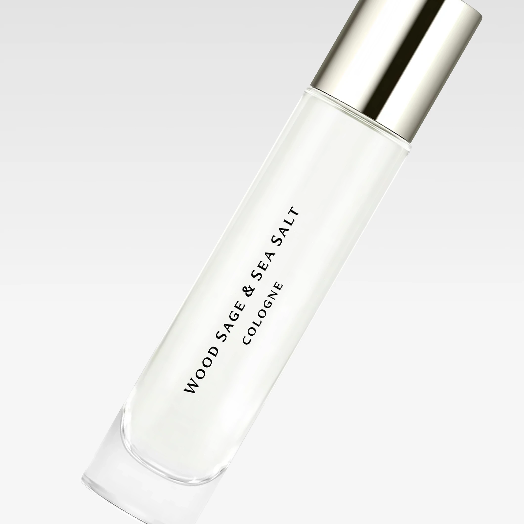 Minimalistisk parfymeflaske med teksten "WOOD SAGE & SEA SALT COLOGNE" mot lys bakgrunn.
