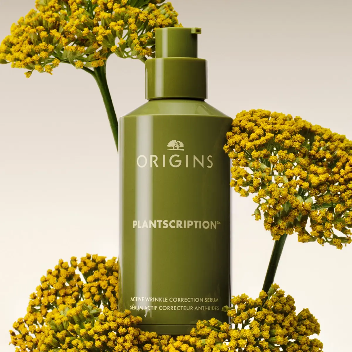 Origins Plantscription Active Wrinkle Correction Serum omgitt av gule blomster mot en lys bakgrunn.