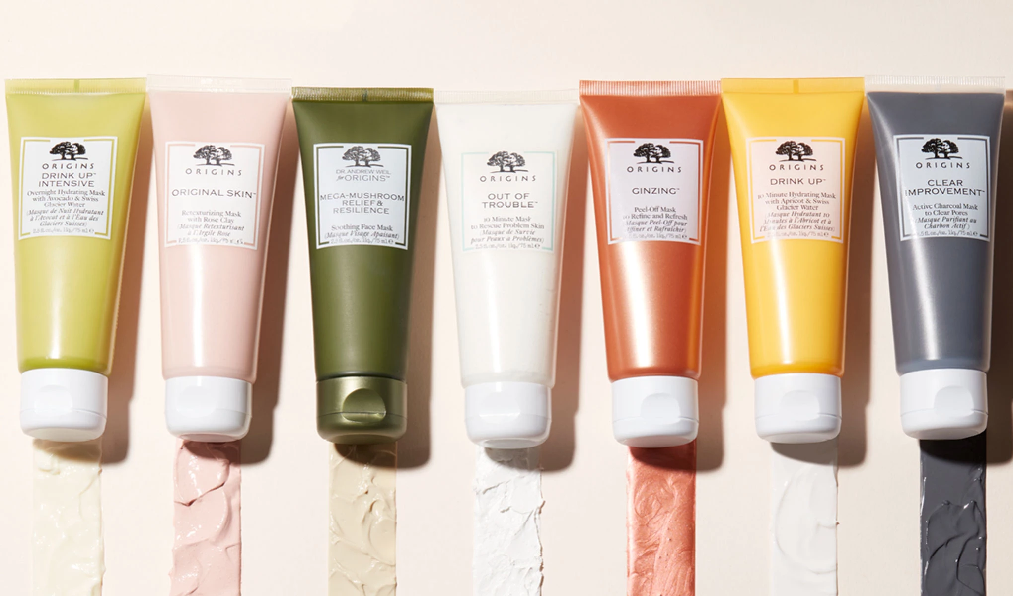 Produkter från Origins med dess innehåll utbredda undertill mot en beige bakgrund i solljus.