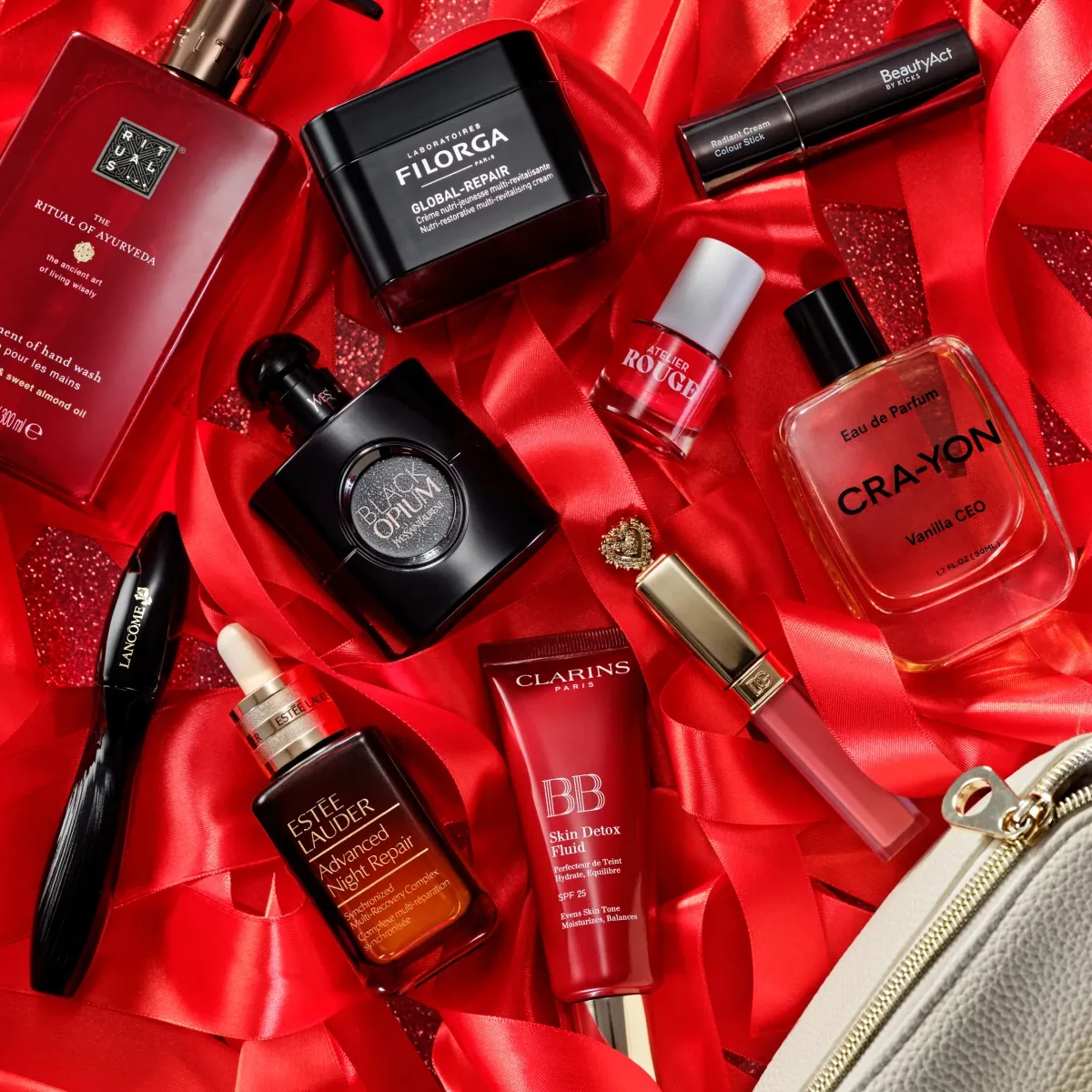 Yksitoista kauneustuotetta eri merkeiltä, levitetty punaisten nauhojen kanssa punakimaltelevalle taustalle.