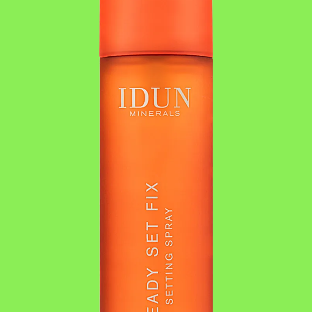 Flaska märkt “IDUN MINERALS Ready Set Fix Setting Spray” mot grön bakgrund.