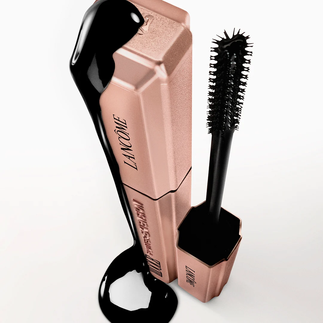 Nærbilde av en person som påfører Lancôme mascara på øvre vipper, med tydelig børste og åpnet hylse nær øyet.