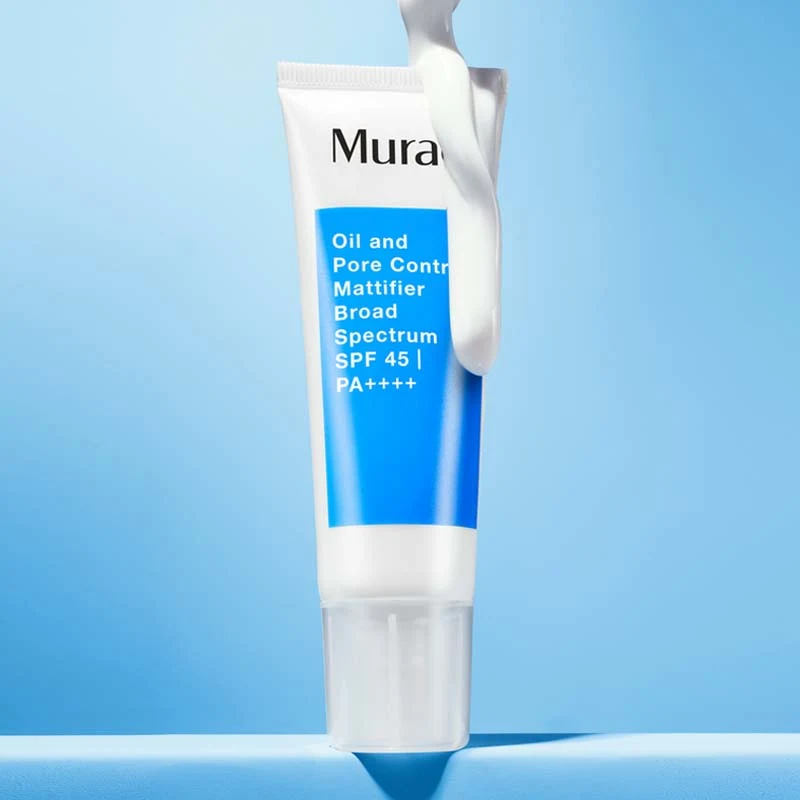 Ansiktskrem fra Murad plassert mot en lyseblå bakgrunn. Tuben er hvit med en blå etikett som viser produktnavnet. På toppen av tuben er det påført en hvit krem som fremhever produktets tekstur og solbeskyttende egenskaper.