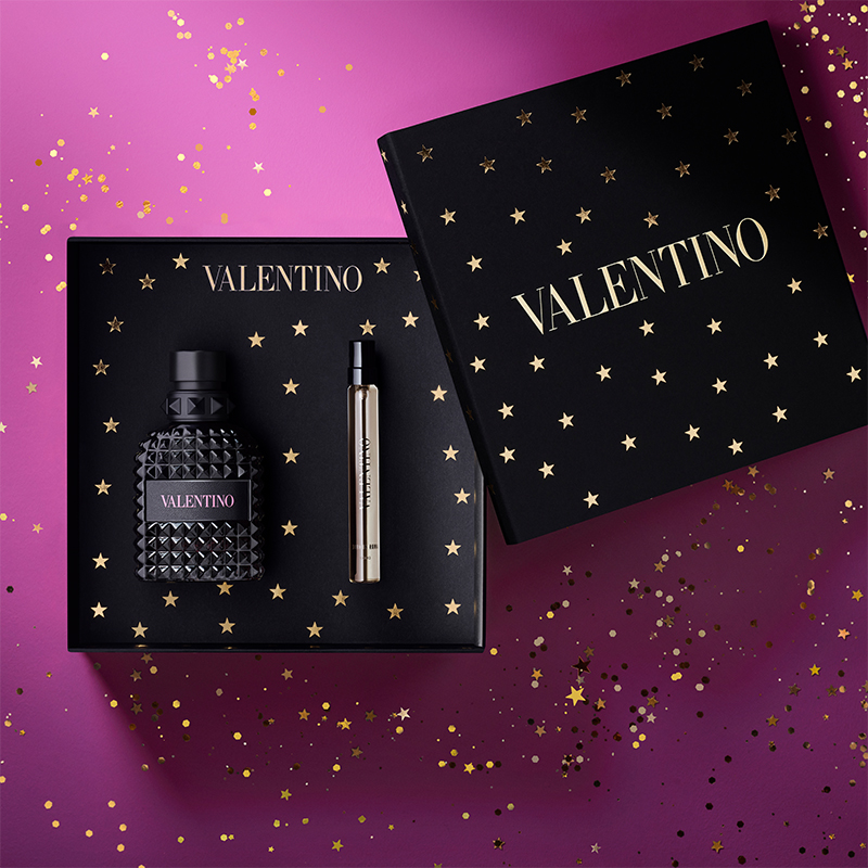 Valentino couture-lahjasetti Uomo Born In Roma Intense parfyymi mustassa tähtikuvioidussa ja tyylikkäässä laatikossa. Täydellinen joululahja ja lahjavinkki hänelle violetilla kimaltelevalla taustalla.