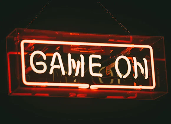 Neonvalokyltti, jossa lukee "GAME ON"