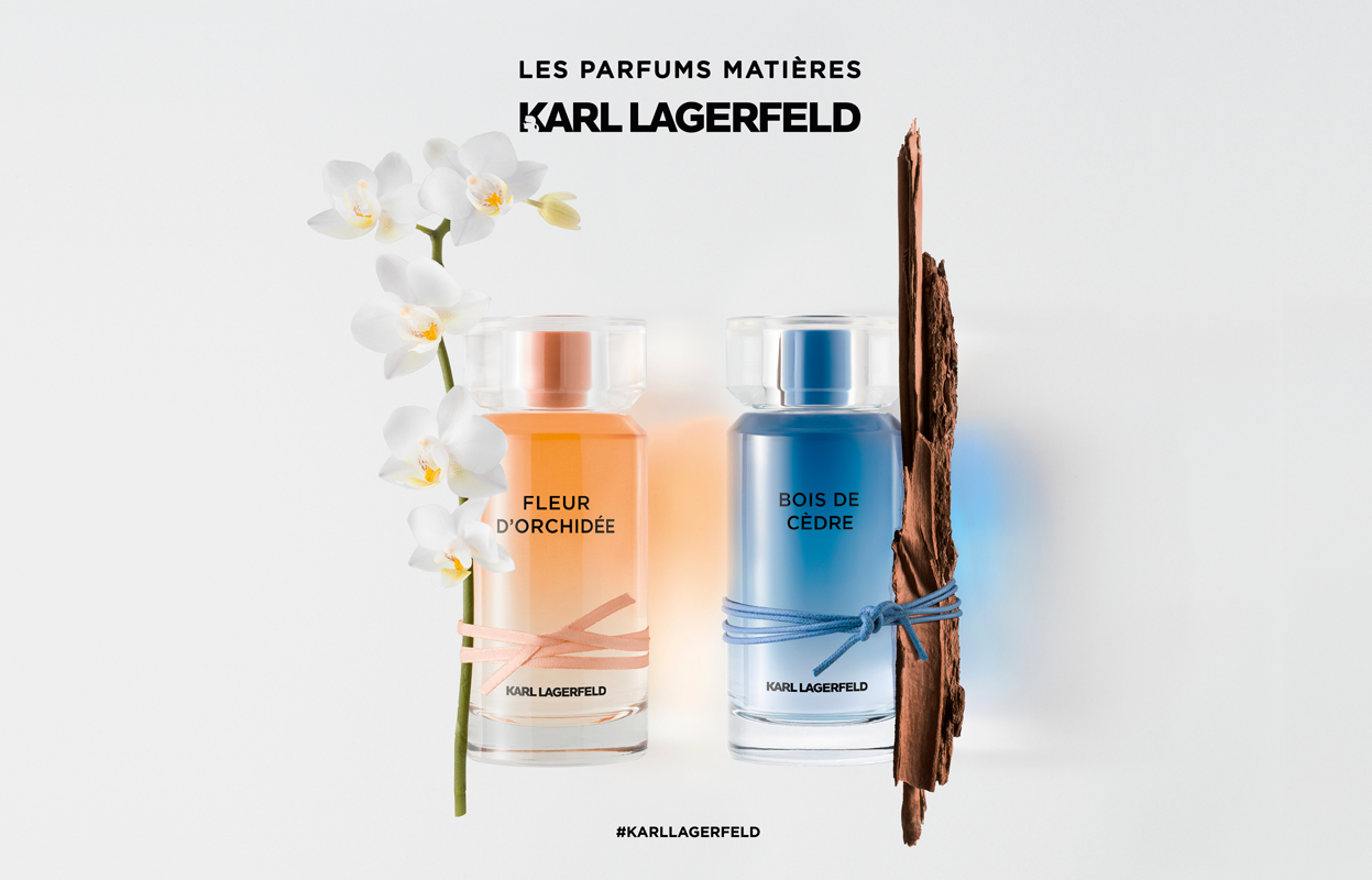 To parfymeflasker fra Karl Lagerfelds «Les Parfums Matières»-kolleksjon. Den venstre flasken, «Fleur D'Orchidée», er oransje og dekorert med hvite orkideer. Den høyre flasken, «Bois de Cèdre», er blå og dekorert med et stykke sedertre. Teksten over flaskene lyder «Les Parfums Matières Karl Lagerfeld» og under «#KARLLAGERFELD».