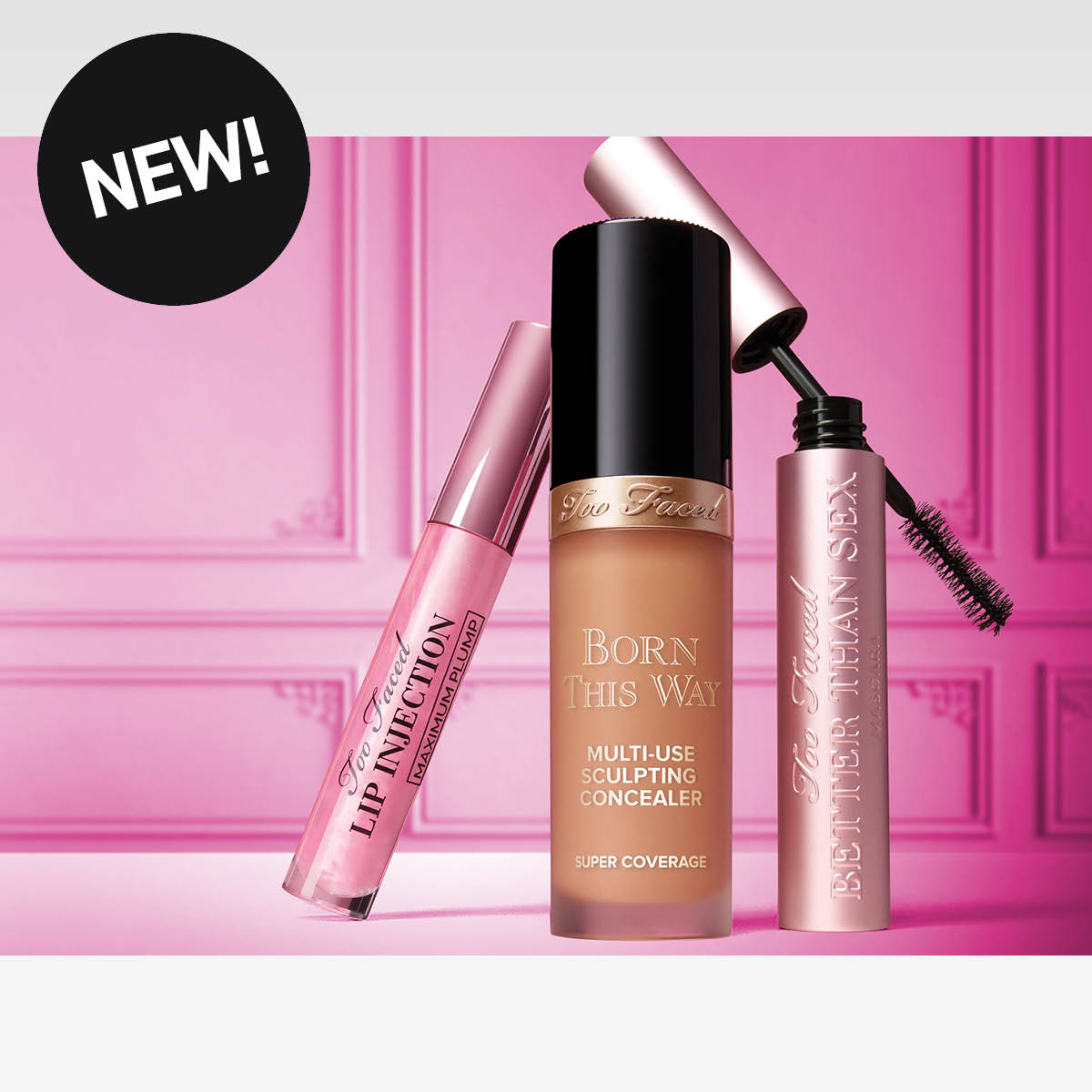 Kolme Too Faced -meikkituotetta vaaleanpunaisella taustalla, NEW!-tekstillä