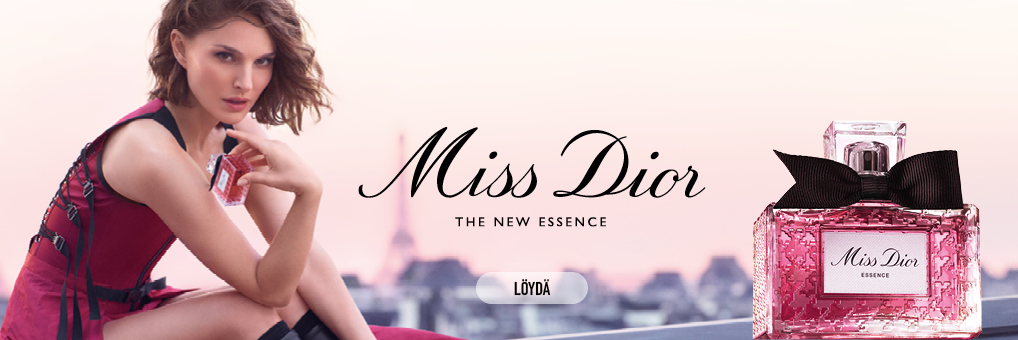 Miss Dior -hajuvesi, uusi Essence. Nainen istuu ulkona ja pitää pulloa kädessään. Taustalla näkyy kaupunkimaisema. Pullo on vaaleanpunainen ja siinä on musta rusetti.