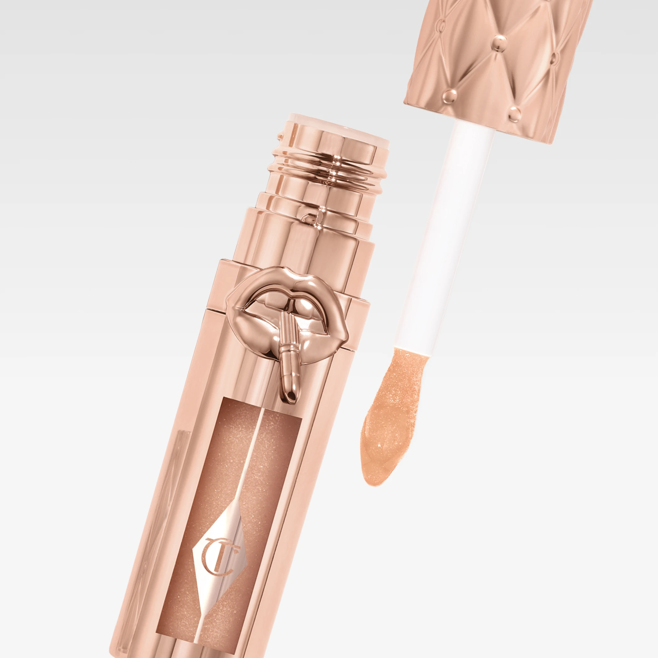 Charlotte Tilbury läppglans i roséguldfärgad förpackning med applikator och logotyp med läppmotiv på tuben.