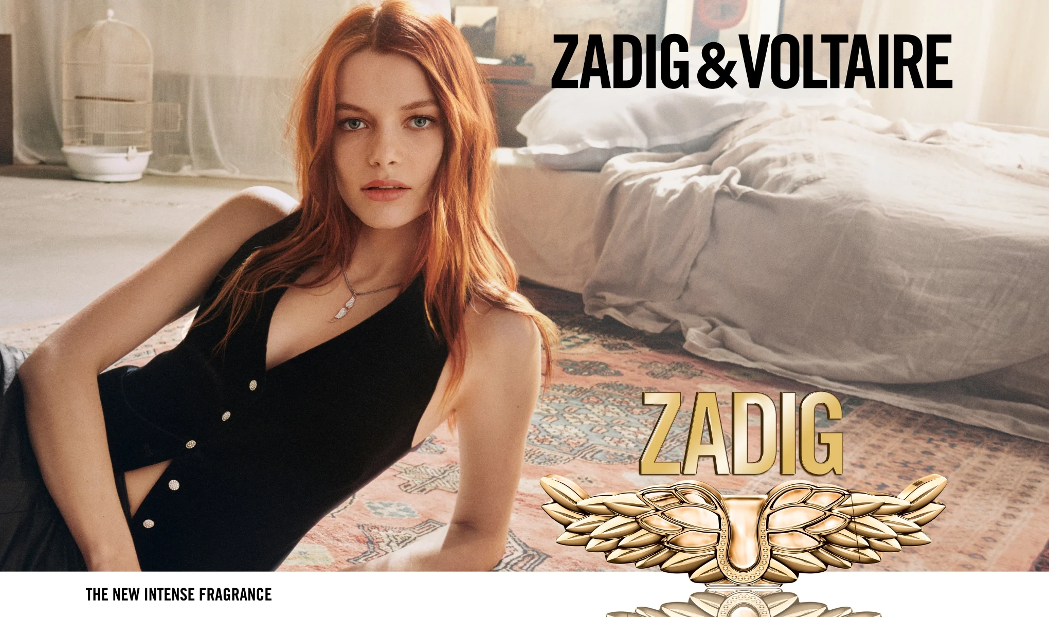 En person ligger på golvet i ett sovrum med en säng i bakgrunden, tillsammans med Zadig & Voltaire-parfym och texten “The New Intense Fragrance”.