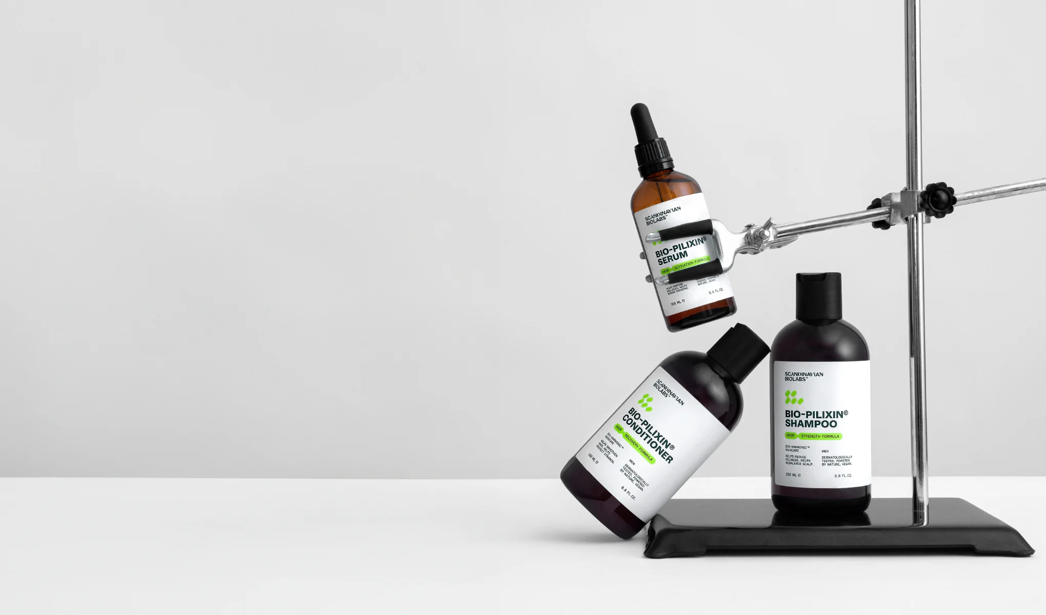 Tre hårpleieprodukter mot en hvit bakgrunn. Øverst en brun flaske "Bio-Pilixin Serum", i midten en svart flaske "Bio-Pilixin Conditioner" og nederst en svart flaske "Bio-Pilixin Shampoo".