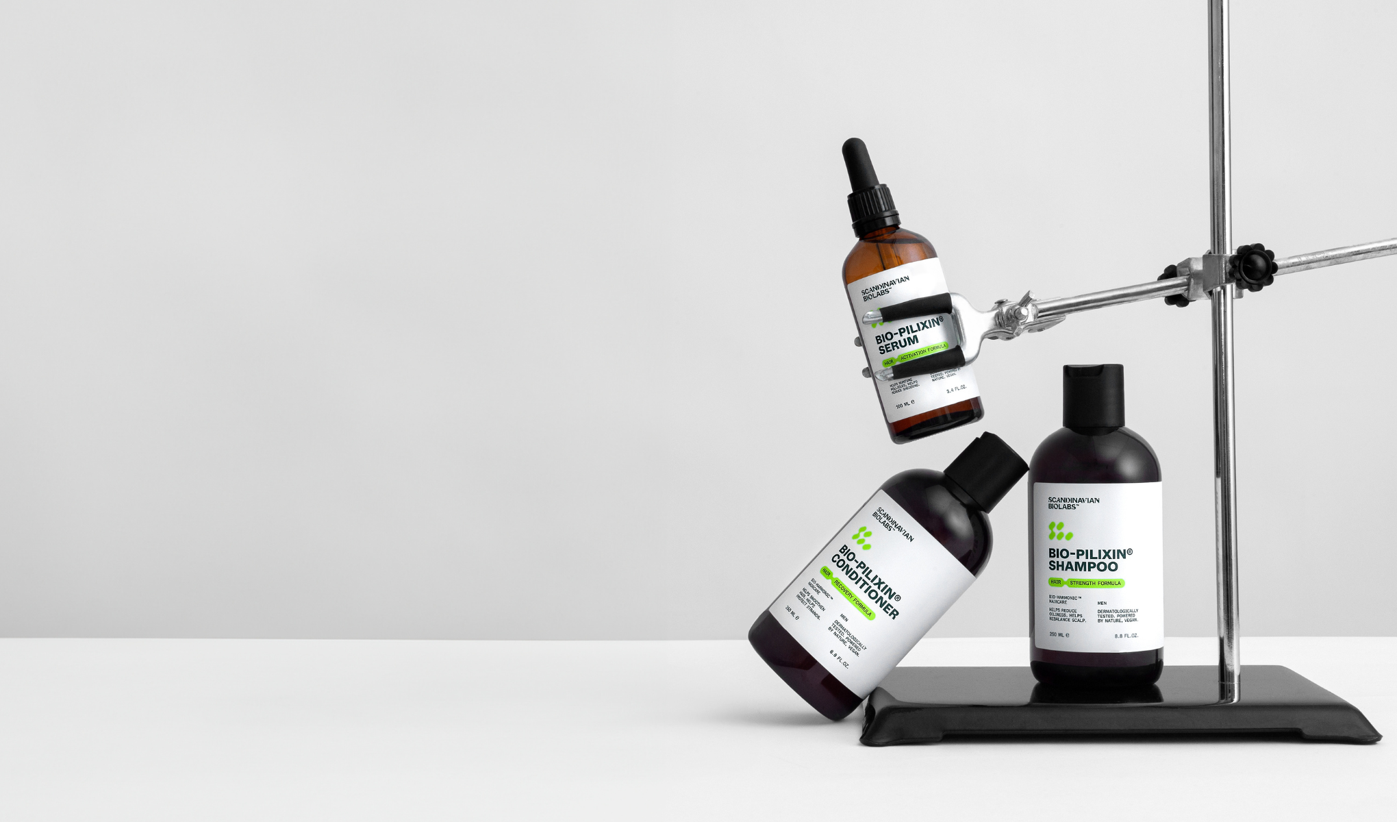 Tre hårvårdsprodukter mot en vit bakgrund. Överst en brun flaska "Bio-Pilixin Serum", i mitten en svart flaska "Bio-Pilixin Conditioner" och längst ner en svart flaska "Bio-Pilixin Shampoo".